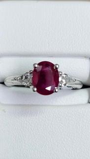 White gold diamond engagement ring with pear shapes and oval ruby center